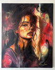An expressive portrait painting of a woman with dark hair and glowing warm highlights, rendered in black, red, orange, and purple tones. The artwork fills most of the frame and appears mounted against a light wall.